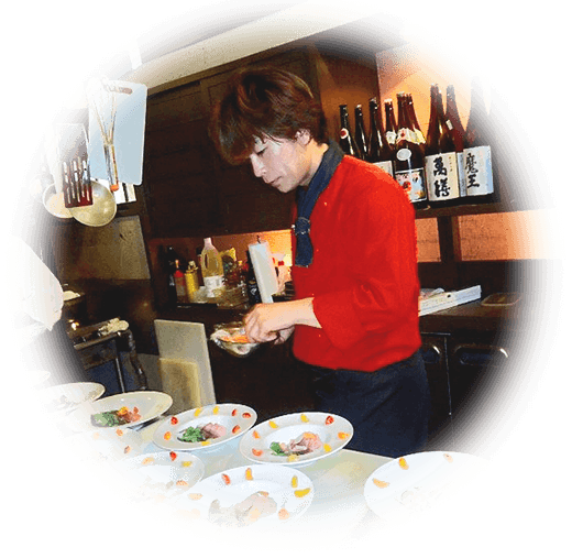 写真:赤いコックさん済藤正志シェフが真剣に料理をこしらえている